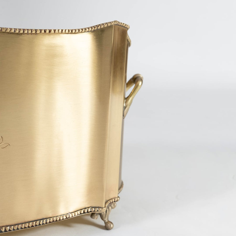 Closeup of gold metal container side view highlighting smooth brushed surface curved edge and premium decorative craftsmanship.
