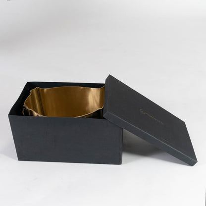 Gold oval metal planter with side handles and engraved crest displayed empty on a plain white background front view.