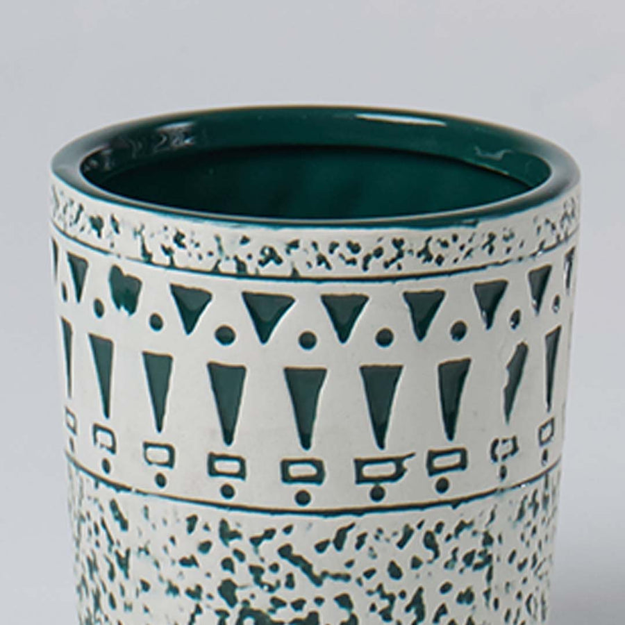 Closeup of ceramic planter showing teal geometric detailing and speckled texture for a stylish modern decor accent.