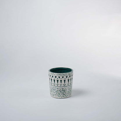 Small ceramic tumbler vase featuring a textured white distressed tribal pattern over a teal base on clear white background.