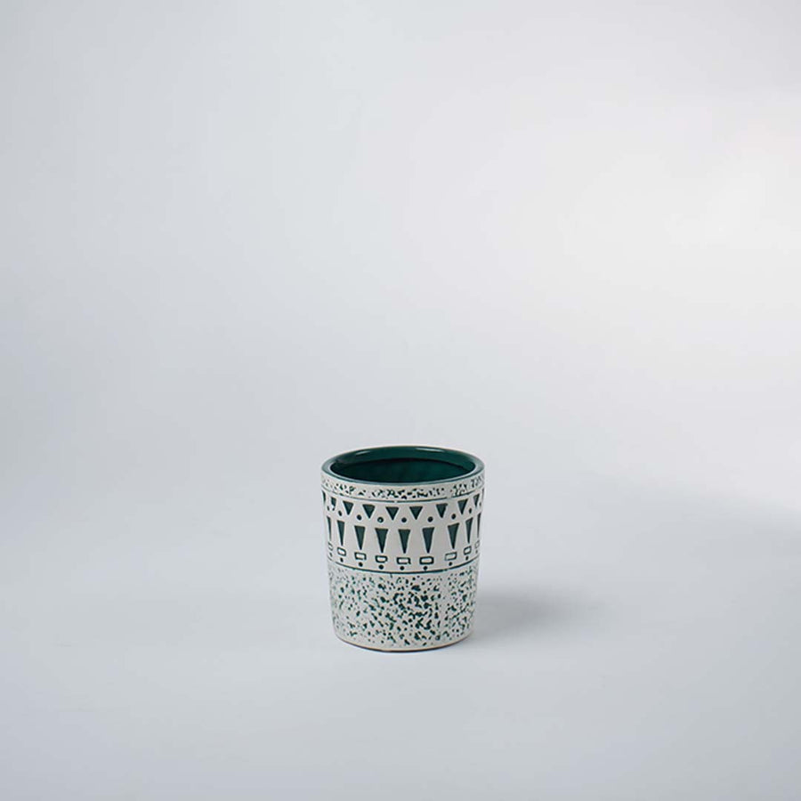 Small ceramic tumbler vase featuring a textured white distressed tribal pattern over a teal base on clear white background.