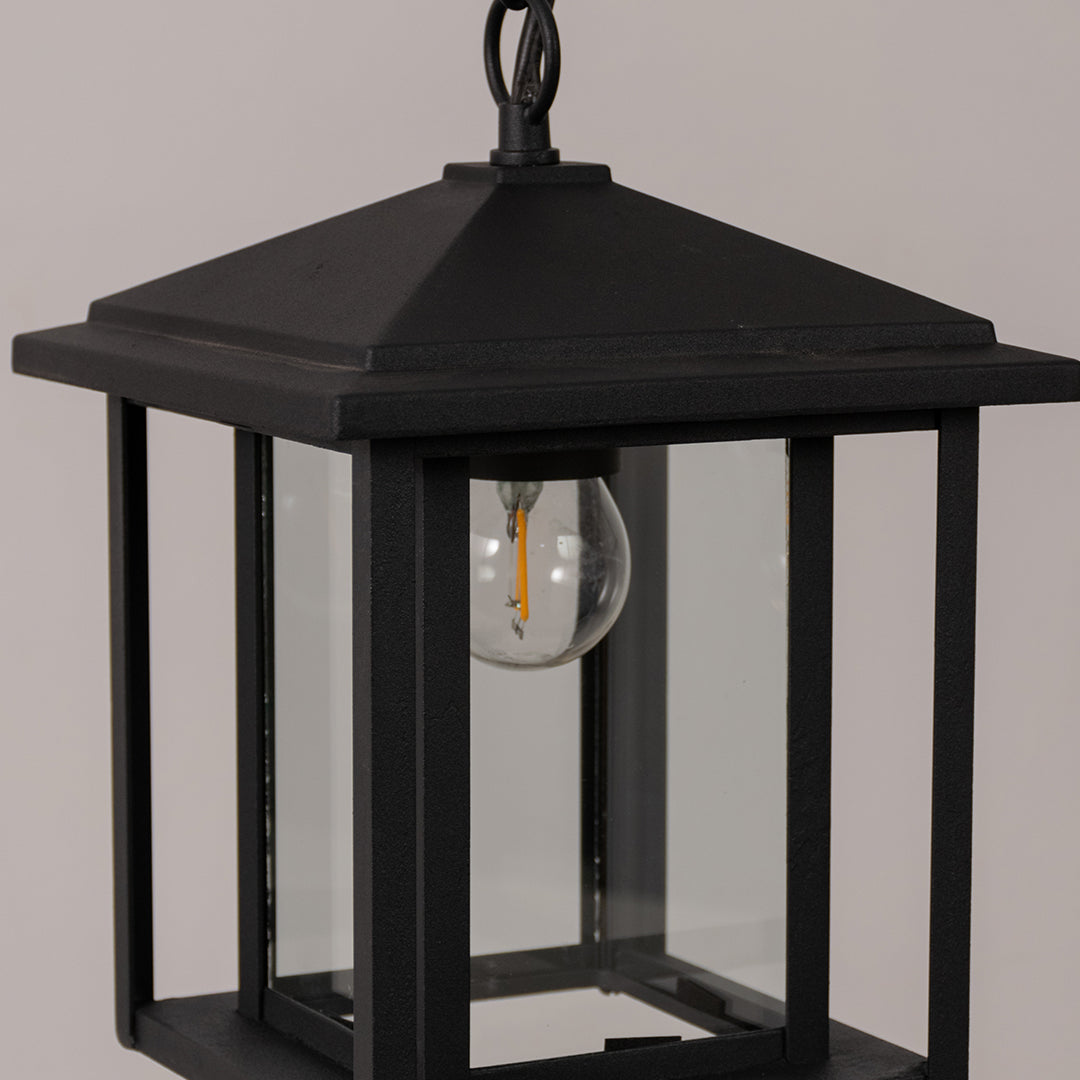 Closeup outdoor lantern in black metal with glass panels for entrance or garden decor lighting white background.