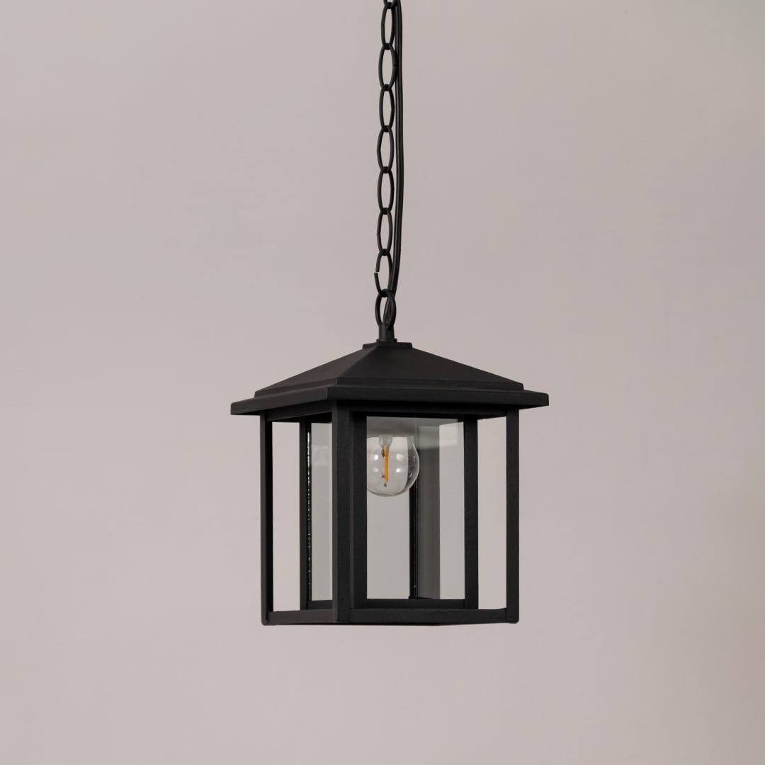 Black metal outdoor hanging lantern with clear glass panels shown unlit on a white background for product clarity.