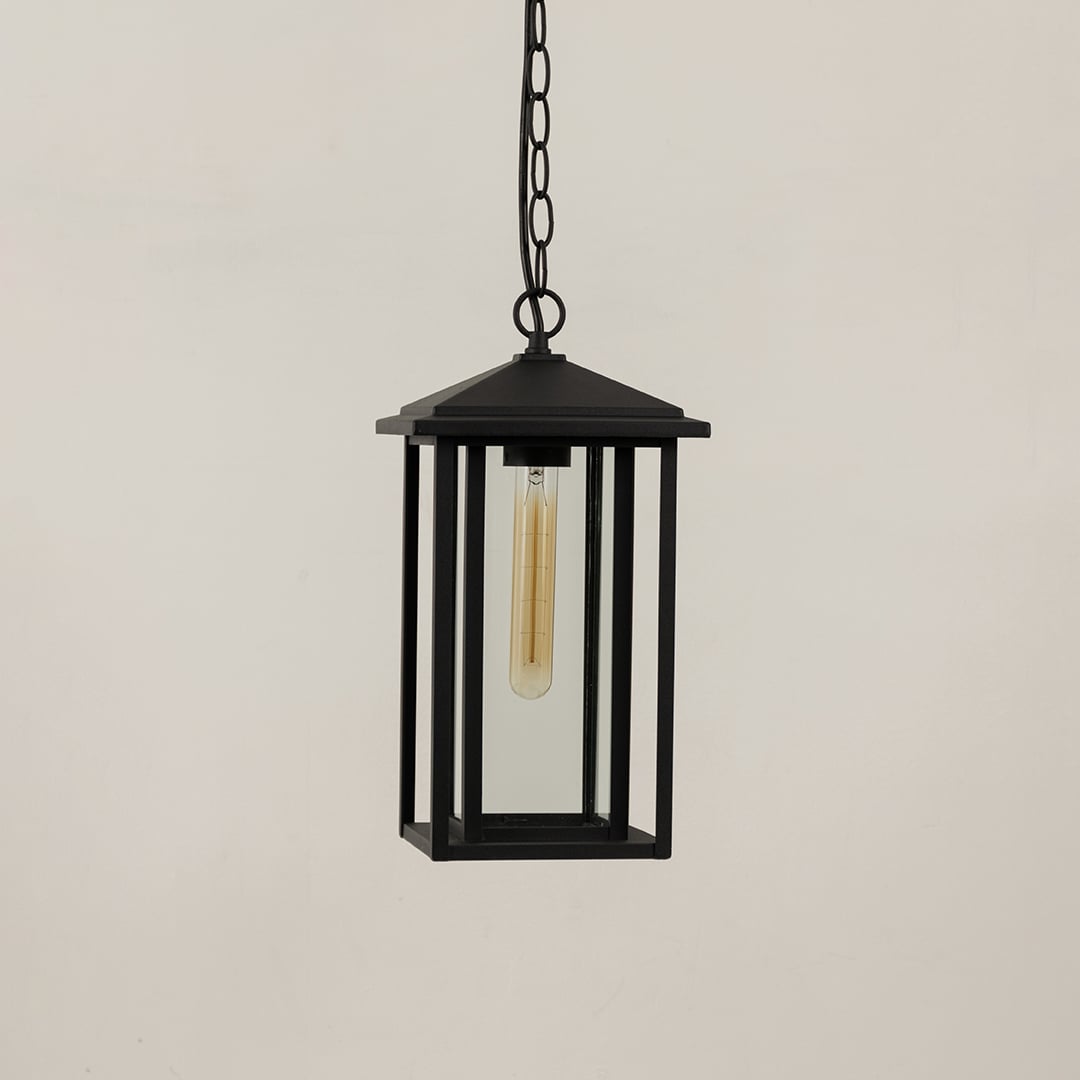 A stylish black metal hanging lantern shown on a plain white background highlighting its tall rectangular frame and transparent glass sides with the light switched off.