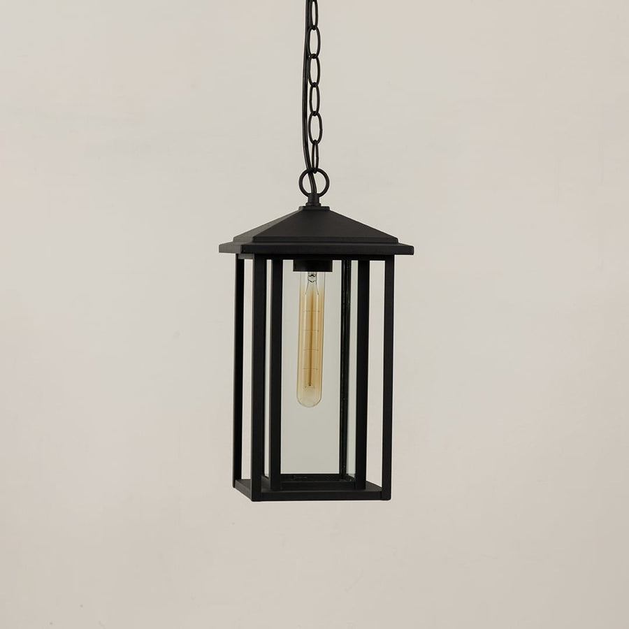 A stylish black metal hanging lantern shown on a plain white background highlighting its tall rectangular frame and transparent glass sides with the light switched off.