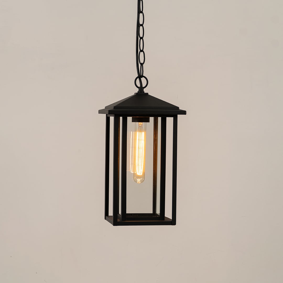 A sleek black hanging lantern displayed on a white background showing its clean modern frame and clear glass panels with lights on for a clear product-only view.