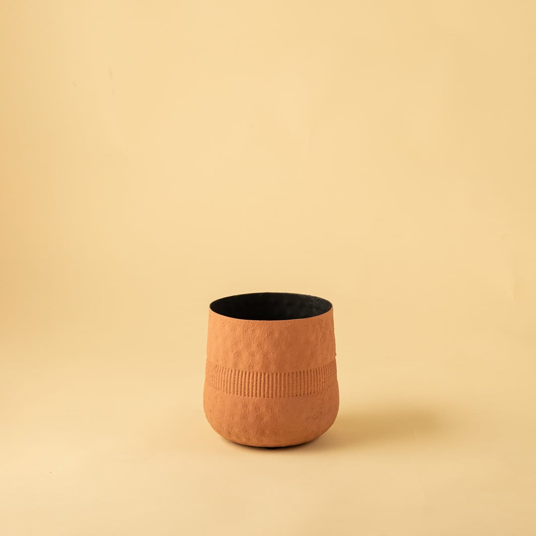 Small terracotta textured pot with black interior displayed on a clean white background for minimal modern home decor.