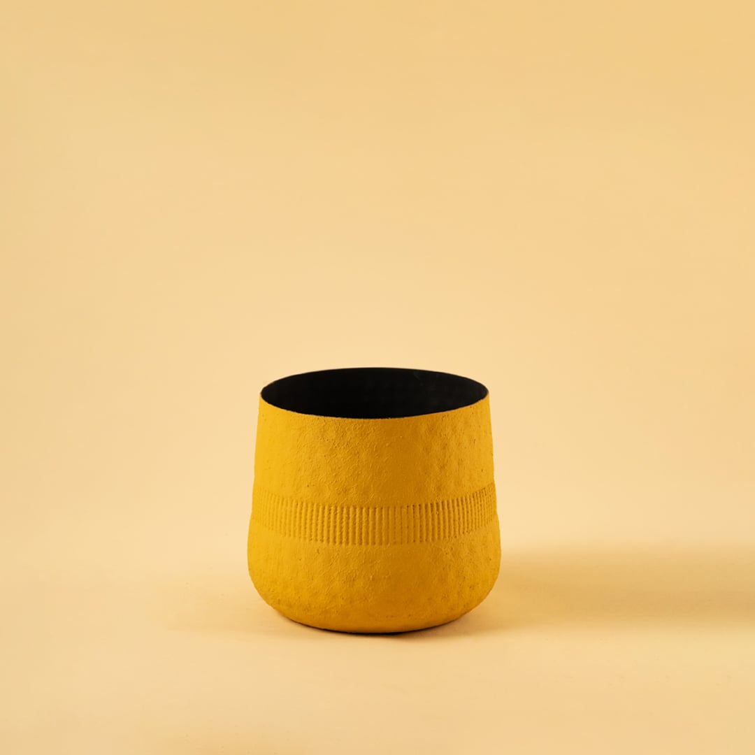 Yellow textured pot with black interior displayed on a clean white background for bold modern minimal home decor.