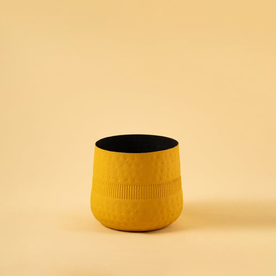 Yellow textured pot with black interior displayed on a clean white background for bold modern minimal home decor.