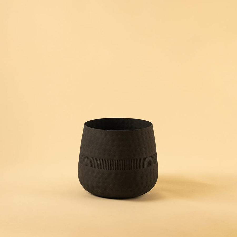 Black textured pot with matte finish and ribbed pattern displayed on a clean white background for minimal modern decor.