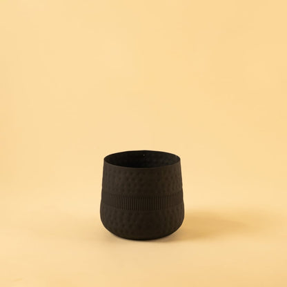 Small black textured pot with ribbed design and matte finish displayed on a clean white background for minimal modern decor.