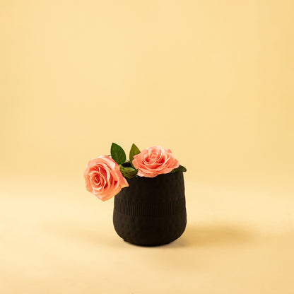 Matte black textured small vase with pink flowers for modern home decor and stylish tabletop accent display.