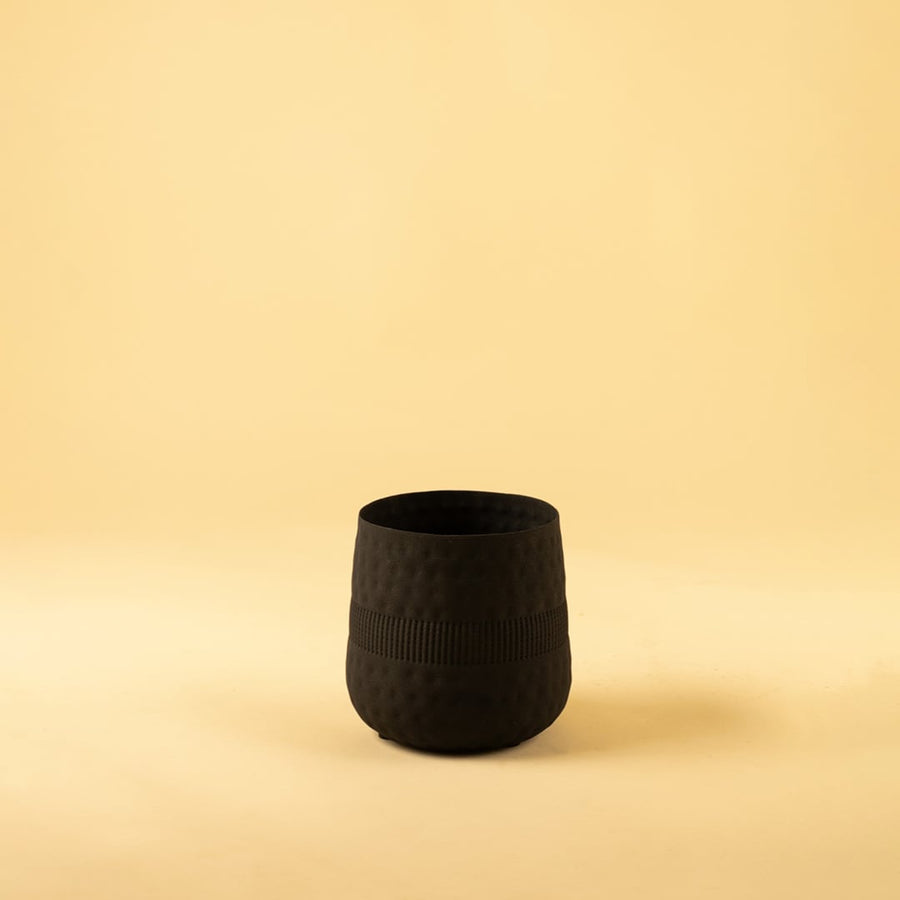 Small black textured pot with matte textured finish displayed on a clean white background for minimal modern decor.