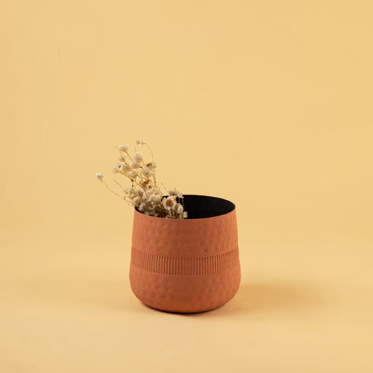 Terracotta textured pot with matte finish and black interior styled in a cozy modern home setting adding warm natural decor.