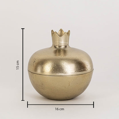 Close view of gold pomegranate storage jar highlighting smooth metallic finish and sculpted crown lid detail.