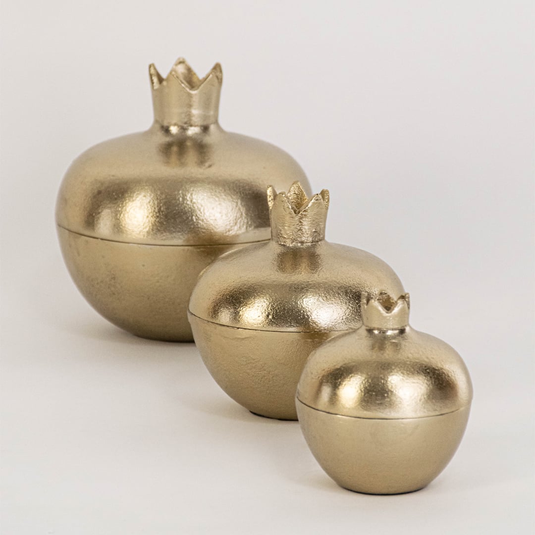 Elegant gold pomegranate jar with removable lid featured in home setting for seasonal decor or hidden storage use.