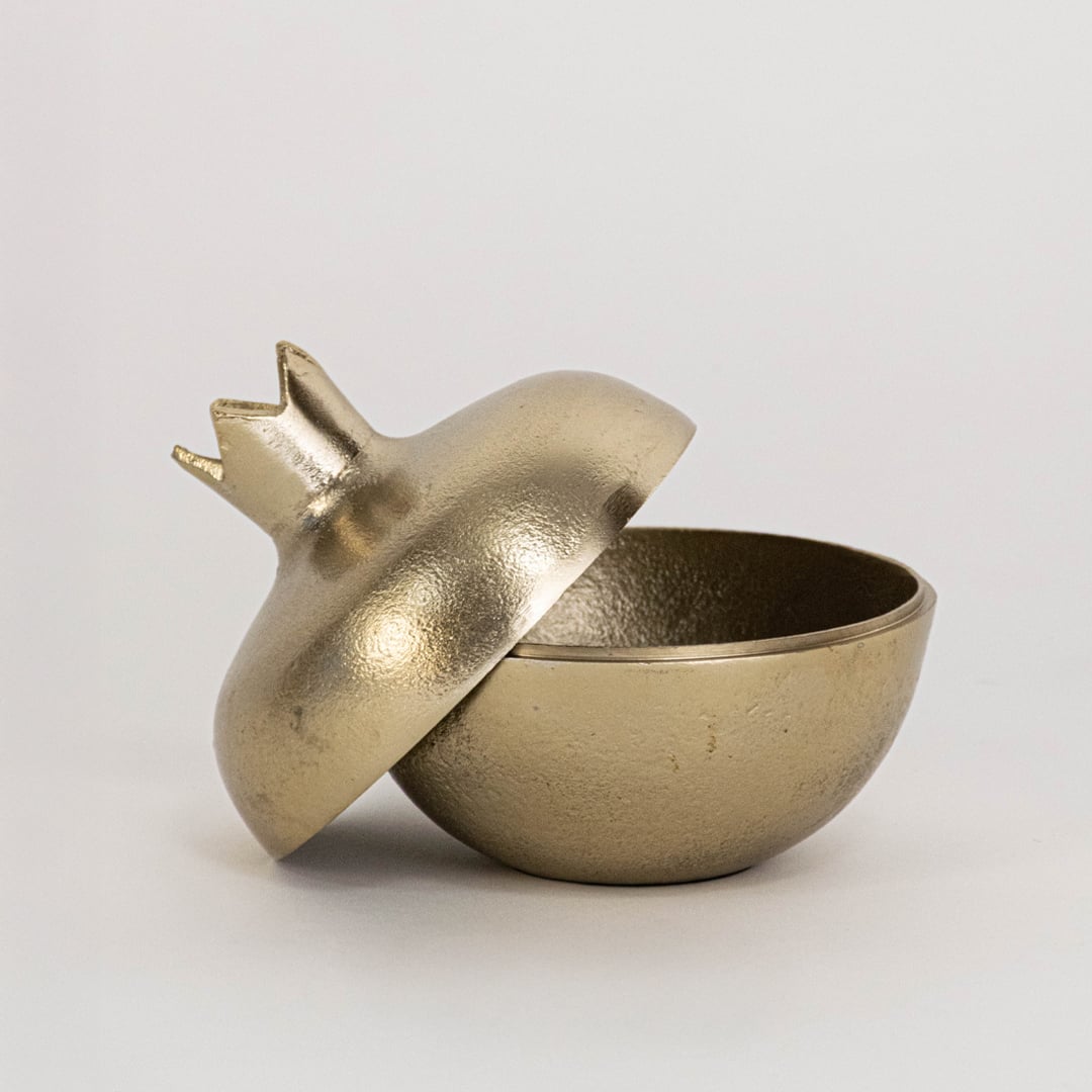 Gold pomegranate decor jar shown in interior setup without white background ideal for styled festive ambiance