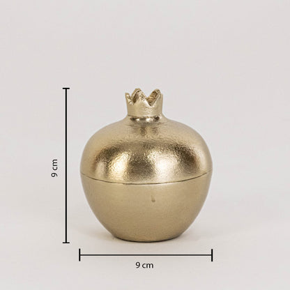 Small gold metal pomegranate jar measuring 9 cm tall and 9 cm wide shown with crown top on white background wall