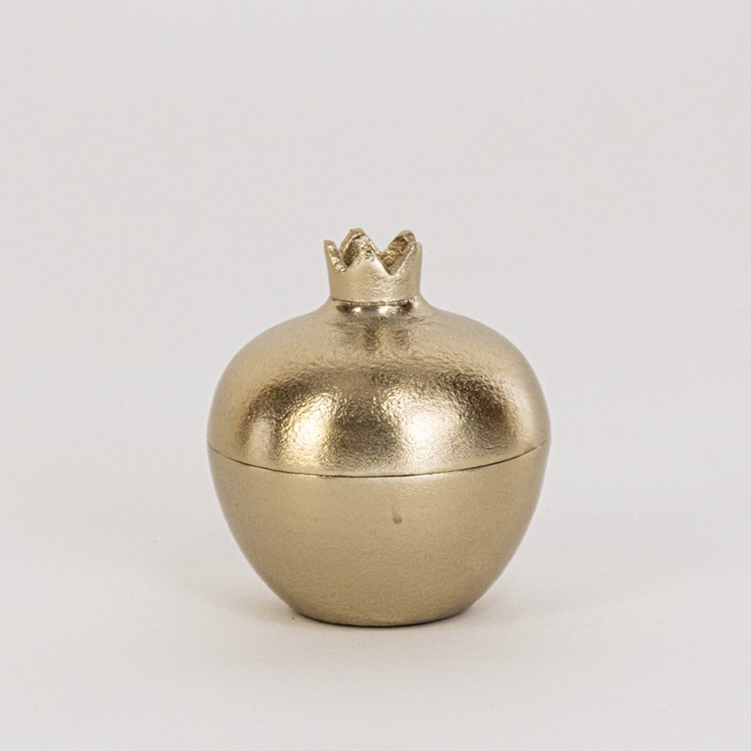 Mini gold pomegranate jar shown in room setup without white background adding subtle accent to home decor styling