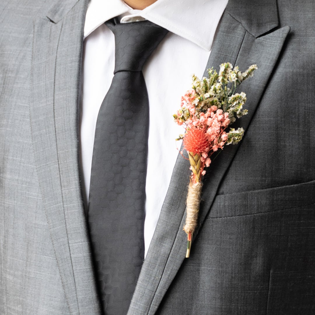 Rustic dried flower boutonniere with preserved red bloom white filler flowers and jute wrap perfect for groom wedding accessory.
