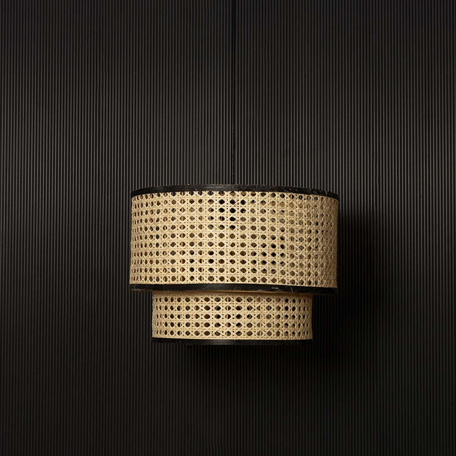 Bohemian rattan pendant light with black rim and natural weave displayed off against dark background decor.