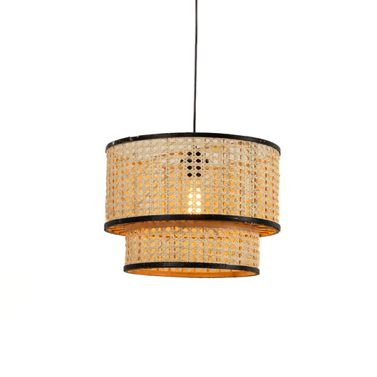 Round woven rattan pendant light with black trim illuminated for warm modern boho decor style.