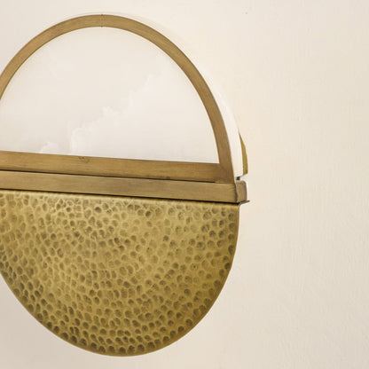 Closeup of textured gold metal wall light for elegant hallway and contemporary decor styling spaces.

