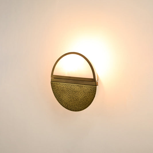 Modern gold metal wall light with warm ambient glow for stylish bedroom and luxury decor spaces.