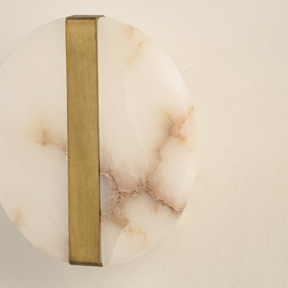 Closeup of marble and gold metal wall light for elegant hallway and luxury decor styling spaces.