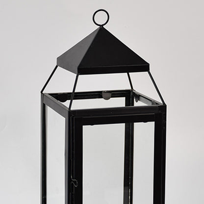 Closeup of black metal lantern with clear glass panels for modern tabletop decor styling use.