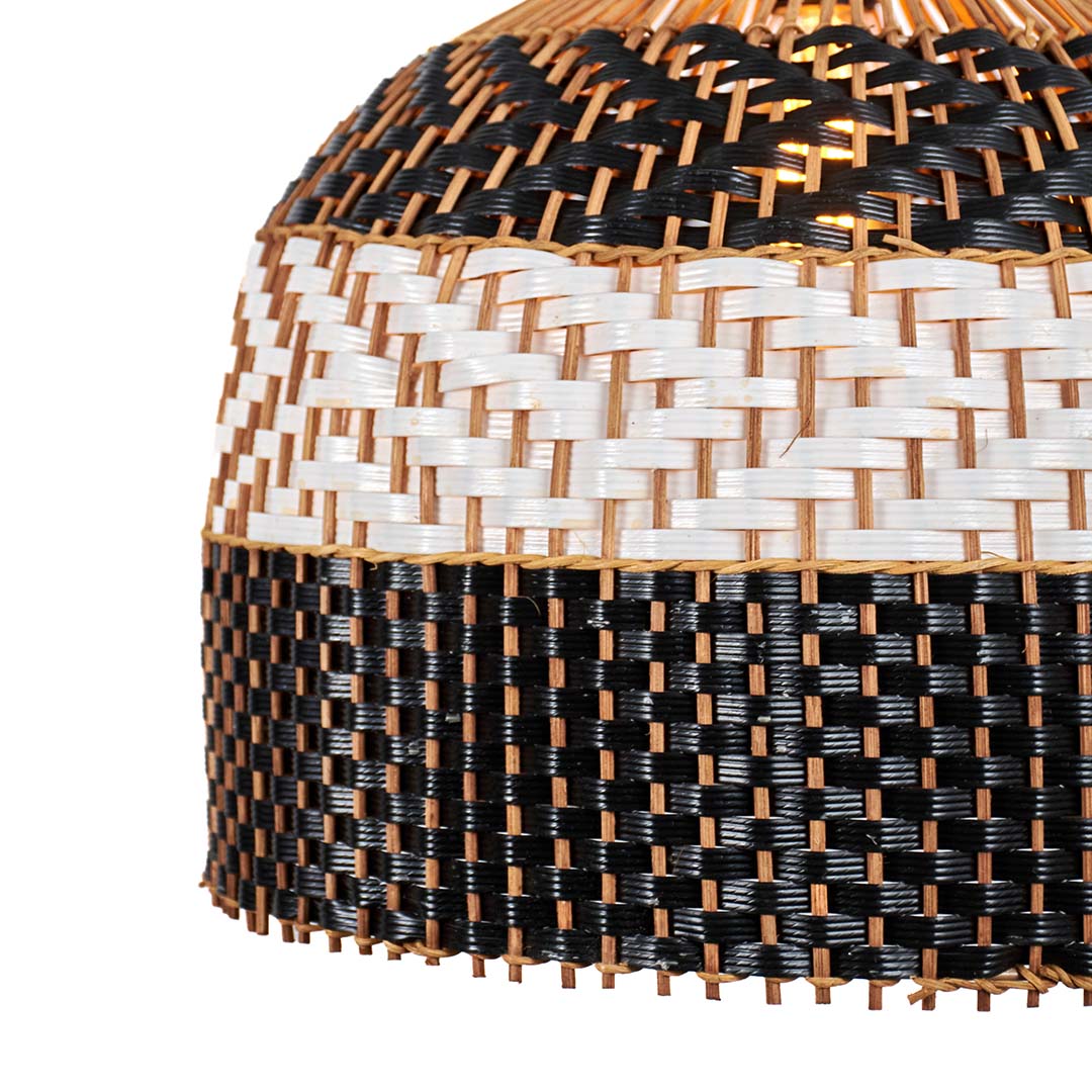 Close view woven rattan pendant light with black and natural checker pattern texture against soft neutral wall background for stylish modern home decor.

