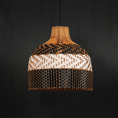 Rattan pendant light illuminated on dark background creating a warm glow through the artistic woven pattern.