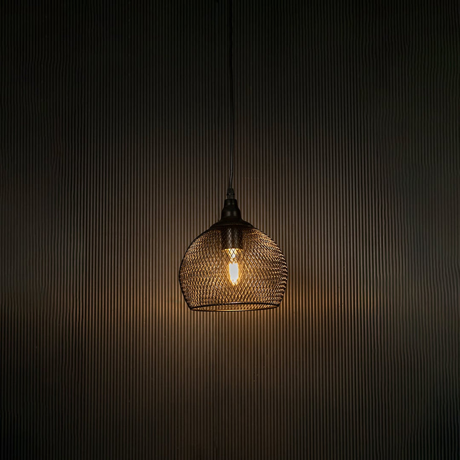 Black mesh pendant light illuminated beautifully against dark background highlighting sleek craftsmanship.