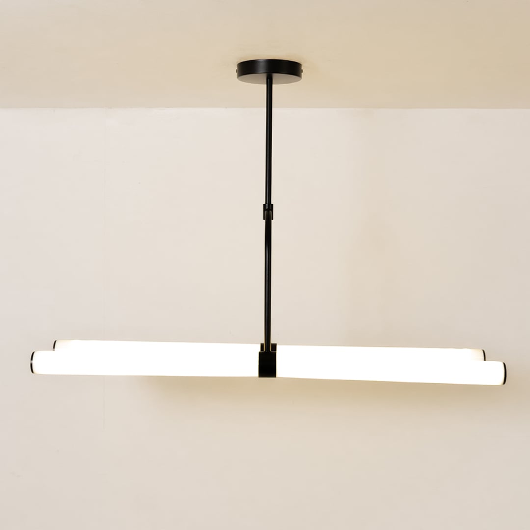 Warm-lit chandelier against a clean white background showcasing its modern linear design and suspended structure.