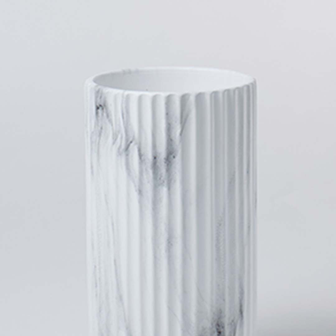 Closeup view of the white ribbed ceramic vase showing marble textured details and a clean contemporary cylindrical design.