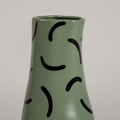 Closeup of green ceramic vase with bold black curved pattern showcasing its smooth finish and modern decorative detailing.