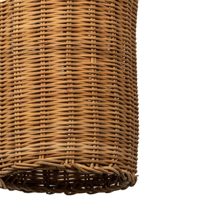 Closeup of woven rattan pendant light with tall bottle shaped wicker shade crafted for rustic bohemian home interiors.