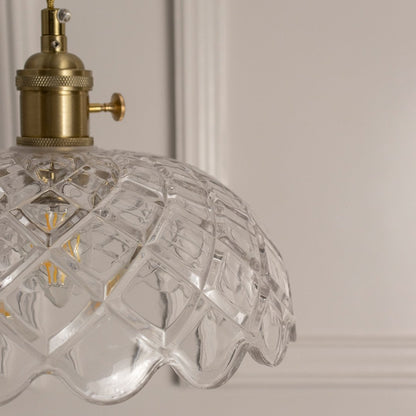 Closeup of clear patterned glass pendant light with gold metal details showcasing premium craftsmanship.