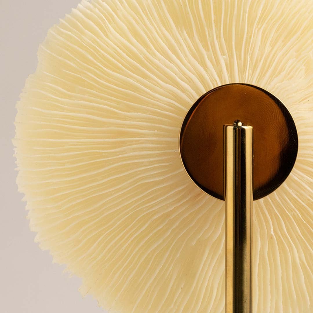 Detailed closeup of textured coral inspired disc on gold stand highlighting its natural artistic decorative design.