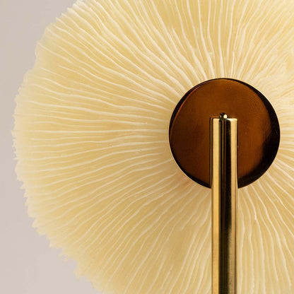 Detailed closeup of textured coral inspired disc on gold stand highlighting its natural artistic decorative design.