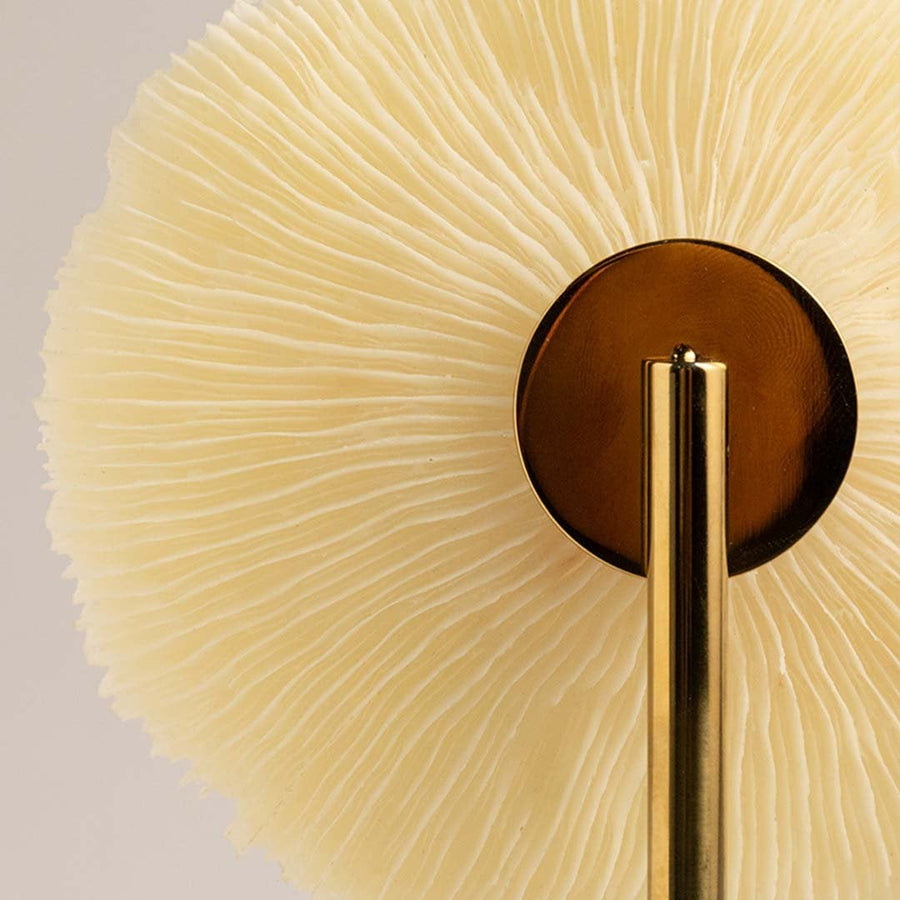 Detailed closeup of textured coral inspired disc on gold stand highlighting its natural artistic decorative design.