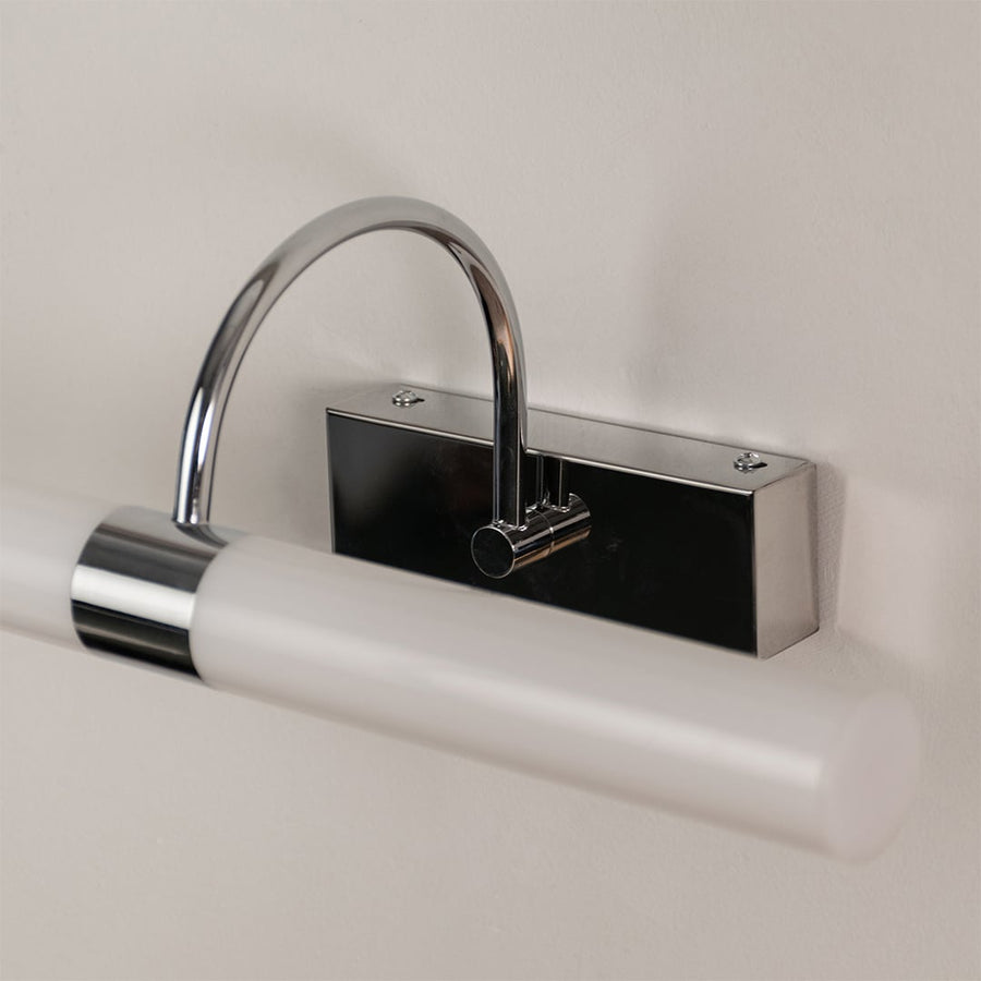 Closeup of white and chrome picture light showing sleek bar design for modern home interior accent lighting and stylish wall decor.
