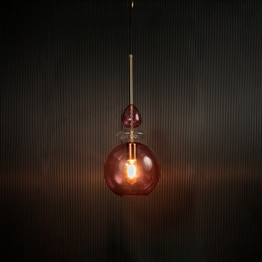 Light off decorative rose pink hanging light with gold accents mounted on a dark ceiling.