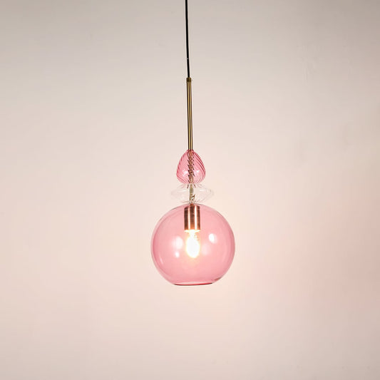 Contemporary pink glass globe pendant light metal hardware white background hanging light.