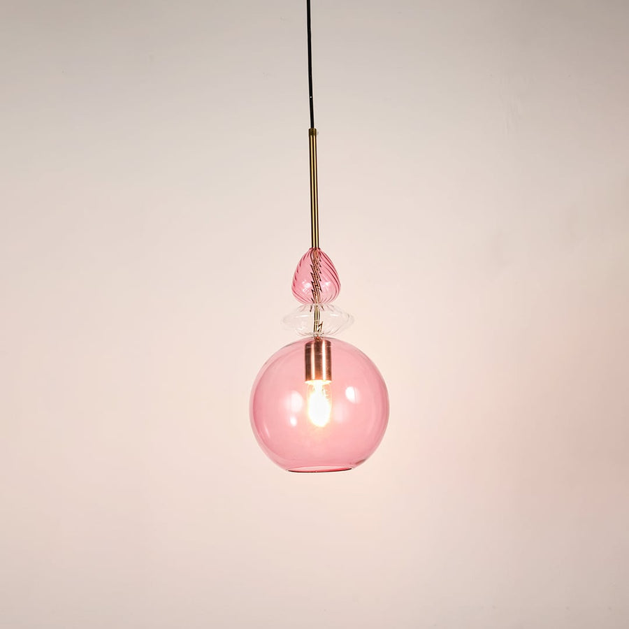 Contemporary pink glass globe pendant light metal hardware white background hanging light.