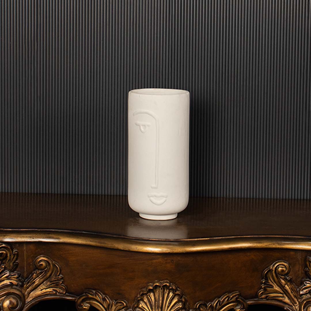 Modern white ceramic face vase highlighted clearly against dark background emphasizing its artistic face design and premium matte finish.