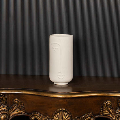 Modern white ceramic face vase highlighted clearly against dark background emphasizing its artistic face design and premium matte finish.