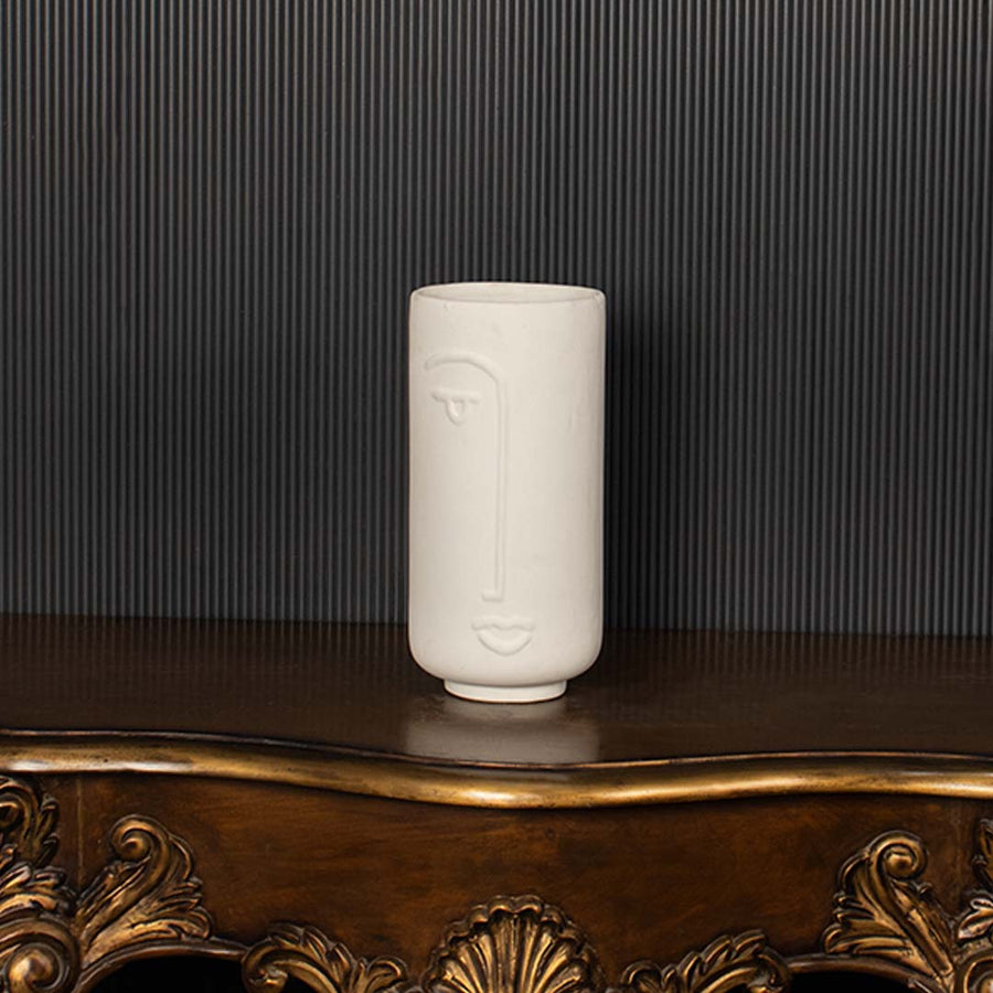 Modern white ceramic face vase highlighted clearly against dark background emphasizing its artistic face design and premium matte finish.