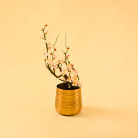 Gold metal planter decor styled in a warm modern room adding a bright elegant accent to living room tables and shelves.