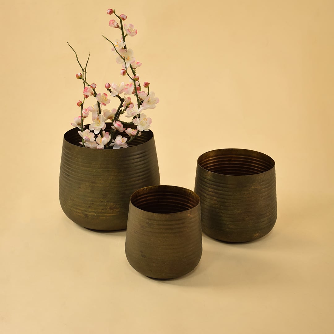 Brown metal planter decor paired with matching pieces creating an earthy modern accent for shelves and living room styling.
